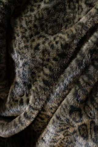 A draped image of the Jaguar Faux Fur Throw, which has a jaguar animal pattern  in dark brown and black tones. 