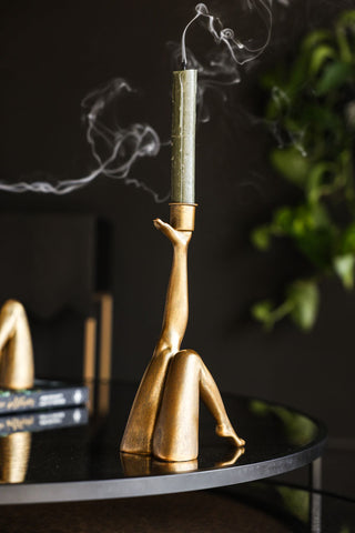 Image of the Kick Gold Leg Candle Holder styled on a black table with a green candlestick