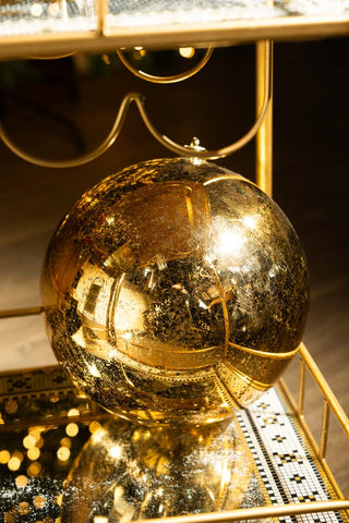 The Large Antique-Style Gold Christmas Bauble styled on a mirrored surface.