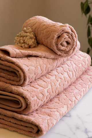 All sizes of the Leopard Jacquard Towels in Dusty Pink shown folded neatly in a stack. 