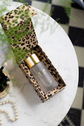The Leopard Love Eau de Toilette - 100ml inthe box, seen from above on a white marble surface with some accessories.