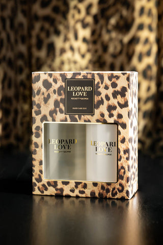 The Leopard Love Hand Care Duo Gift Set displayed in the box on a black surface, with leopard print in the background.