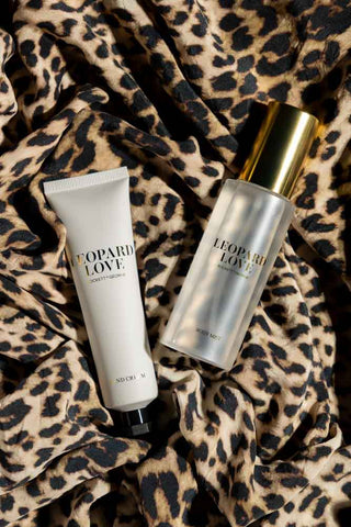 The body mist and hand cream from inside the Leopard Love Hand & Body Beauty Cracker, styled on some leopard print fabric.