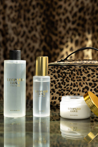 The contents of the Leopard Love Makeup Bag Beauty Gift Set, styled in foront of the bag, with a leopard print background.