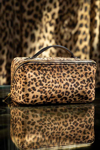 The Leopard Love Makeup Bag Beauty Gift Set styled on a dark surface, with a leopard print background.