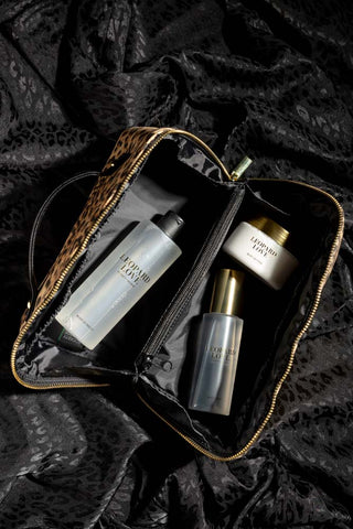 The Leopard Love Makeup Bag Beauty Gift Set seen from above, on some dark leopard print fabric.