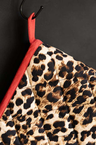 Close-up of the Leopard Love Print & Red Detailing Oven Gloves hanging on a hook.