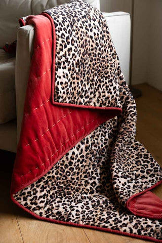Lifestyle image of the Leopard Love Print with Red Reversible Quilt