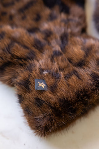 Close-up of the star tag on the Leopard Print Faux Fur Handwarmers.