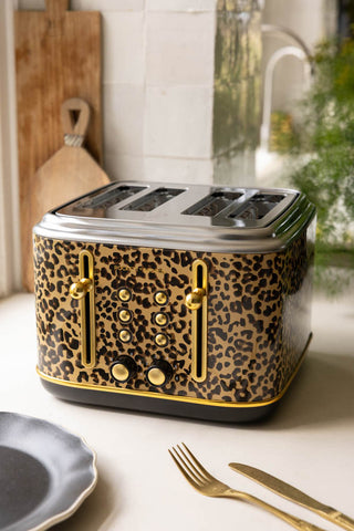 The Fabulous Leopard Print 4 Slice Toaster on a kitchen worktop with various kitchen items and a plant.