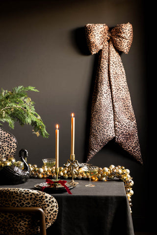 The Leopard Print Velvet Oversized Bow Decoration styled above a festive tablescape.