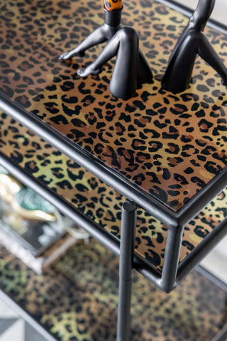 Close-up of the top of the Leopard Print & Glass Console Table with some candlestick holders on.
