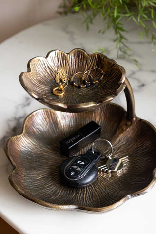 Lifestyle image of the Lily Pad Display Double Dish displayed on a marble table, with jewellery and keys inside. There is a plant in the background. 