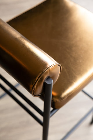 Close-up image of the Burnished Gold Roll Back Bar Stool