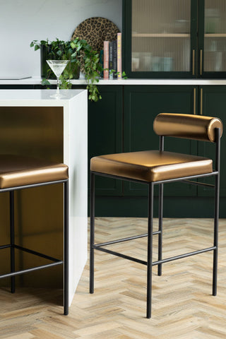 Image of the Burnished Gold Roll Back Bar Stool in a green and gold kitchen.