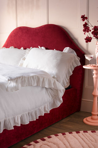 A side angle of the Lips Bed in Cherry Red Needlecord Velvet. 