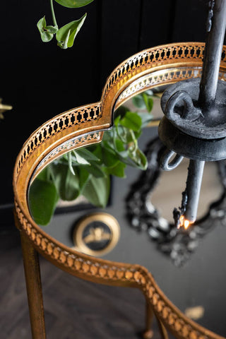 The filigree detail on the edge of the tabletop of the Lucky Clover Mirrored Side Table. 