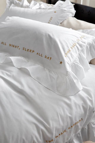 Lifestyle image of the White Mega Frill Duvet Cover and Pillowcase Set styled on a bed showing the detail on one of the pillowcases. 