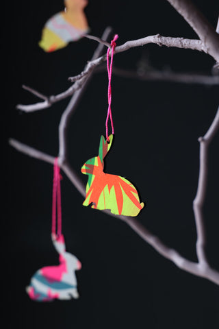 Lifestyle image of the Mixed Colour Bunny Hanging Decorations hanging from branches. 