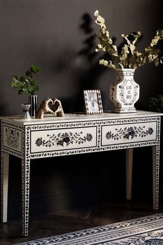 The Monochrome Rose Noir Console Table styled with various accessories on, in front of a dark wall.