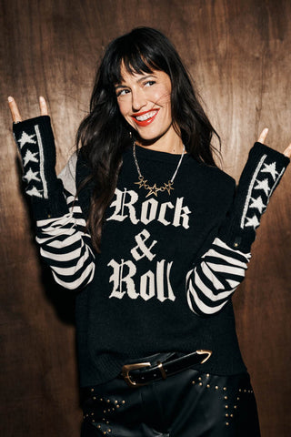 The Monochrome Stars Handwarmers shown on a brunette woman wearing red lipstick with her rms in the air throwing up a rock and roll sign with her hands. 