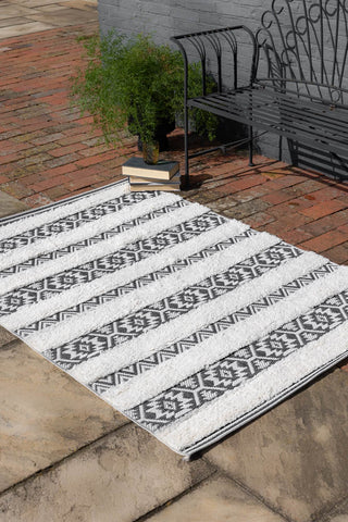 Lifestyle image of the Monochrome Aztec Stripe Indoor/Outdoor Garden Rug - 3 Sizes Available