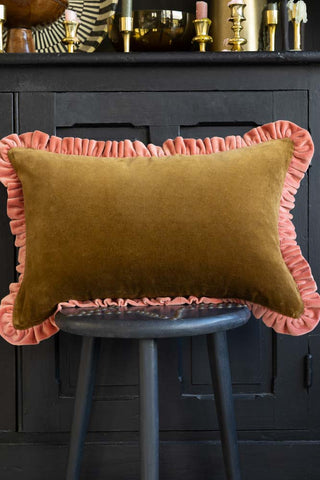 Lifestyle image of the Moss Green Velvet Cushion With Pink Ruffle