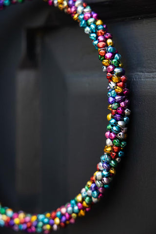 Close detail of the Multicoloured Mini Bell Christmas Wreath on a black door