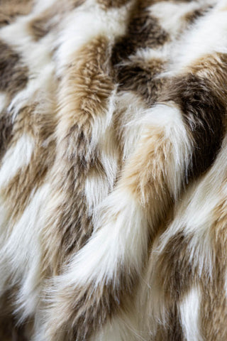 Close up of the Natural Abstract Faux Fur Throw, showing the white, natural and pale brown tones in the abstract animal print. 