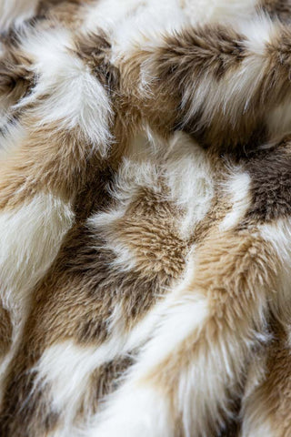 Close up of the Natural Abstract Faux Fur Throw, showing the white, natural and pale brown tones across the pattern on the faux fur. 