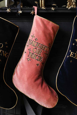 Lifestyle image of the Pink Naughty Or Nice Velvet Christmas Stocking