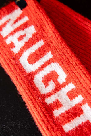 Close-up of the Naughty or Nice Handwarmers on a dark surface.