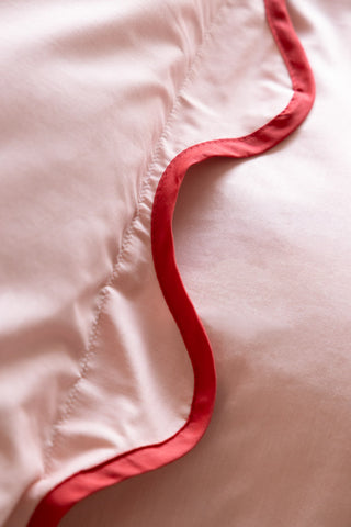 Close-up of the edge of the Ooh La La Pink & Red Scallop Edge Bedding Set.