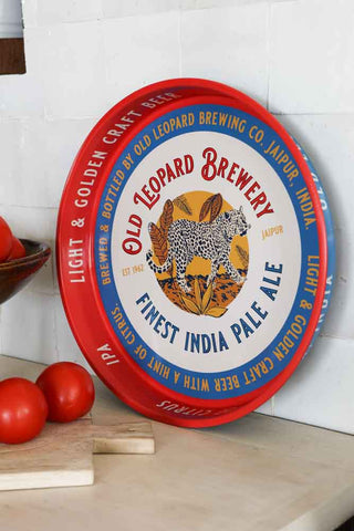 Lifestyle image of the Old Leopard Brewery Serving Tray displayed on a kitchen worktop with kitchen accessories. 