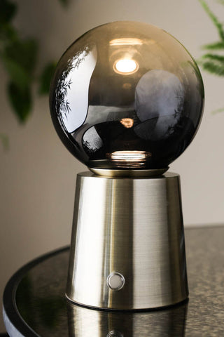 Image of the Ombre Orb Rechargable USB Table Light lit on a table