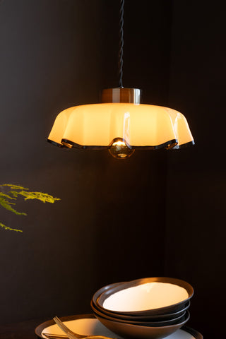 Image of the Monochrome Pleated Glass Easyfit Ceiling Light Shade shown in a kitchen against black walls with the light on. 