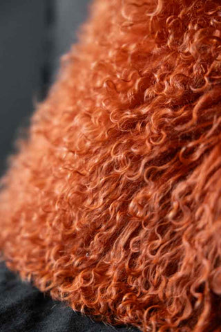 Close-up image of the Orange Mongolian Sheepskin Suede Cushion
