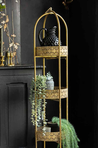 Lifestyle image of Ornate Gold Tall Tray Shelves, styled with plants and various home accessories. 