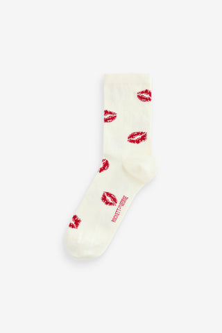 A pair of cream socks with red lips design on a white background.
