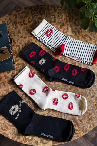 The Pack Of 4 Lips Printed Socks styled on a leopard print table.