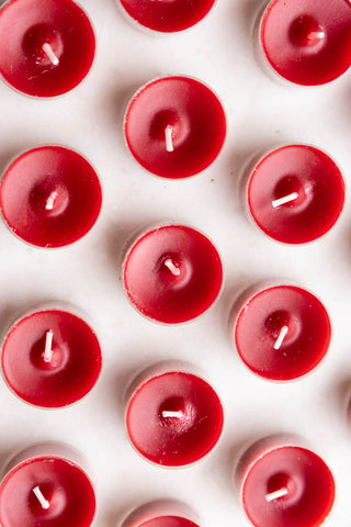 The Pack of 20 Tealight Candles in Deep Red seen from above, arranged on a white surface.