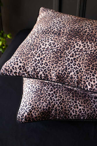 Two leopard print pillows on a dark background.
