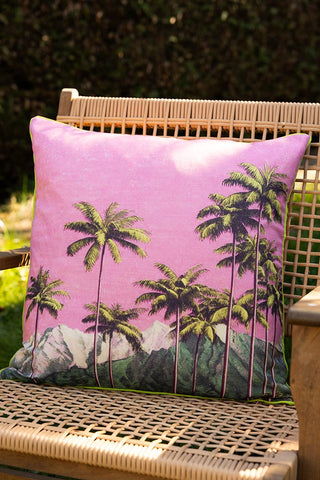 The Palm Springs Outdoor Cushion displayed on a wicker chair outdoors.