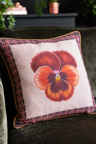 Image of Beautiful Pansy Flower Cushion on a green sofa. 