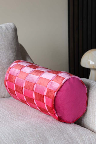 Lifestyle image of the Pink Deco Cut Velvet Bolster displayed on a sofa.