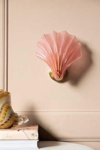 Stunning Pink Glass Shell Wall Light shown with the light off against a beige panelled wall, styled next to a shell