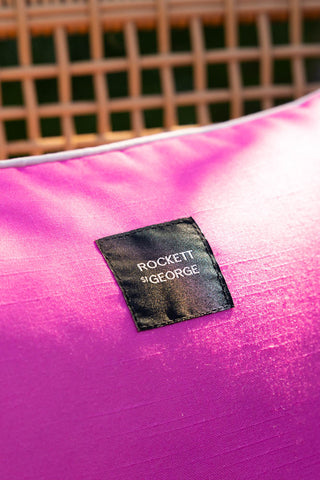 Close-up of the Rockett St George logo on the Pink Palm Tree Outdoor Cushion.