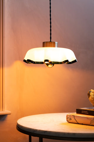 The Pink Pleated Glass Easyfit Ceiling Light Shade shown against plaster pink walls with the lights on. 