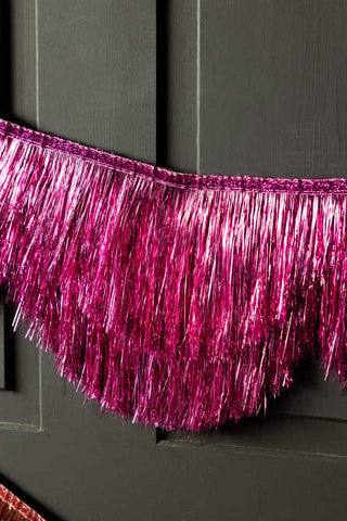 Close-up of the Pink Scalloped Tinsel Garland on a black background.