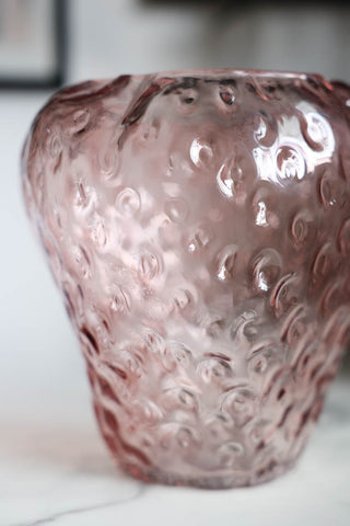Detail image of the Pink Strawberry Glass Vase displayed on a white marble tabletop. 